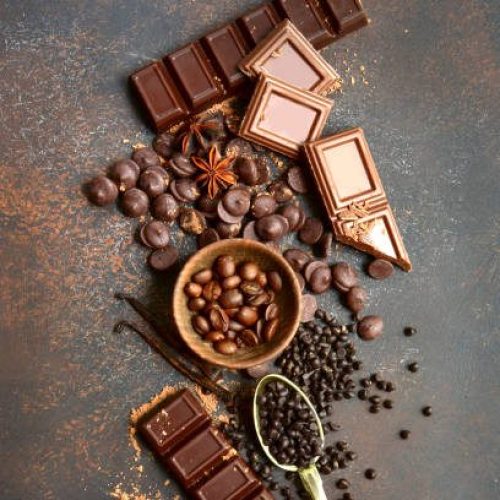 Ingredients for making chocolate cake or candy : chocolate chips, bar and spices on a dark slate, stone or concrete background.Top view with copy space.